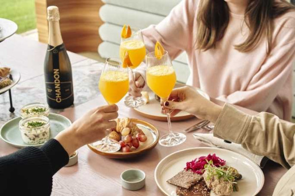 Friends toasting with Chandon sparkling wine over a shared lunch platter at Domaine Chandon, Yarra Valley