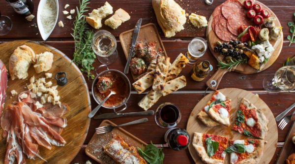 Overhead view of shared lunch platters at Killara Estate, including wood-fired pizza, charcuterie and meatballs