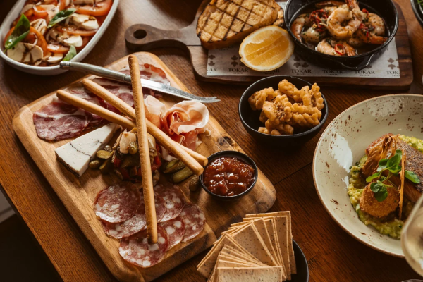 Shared lunch spread at Tokar Estate featuring charcuterie, salt and pepper squid, chilli prawns and risotto
